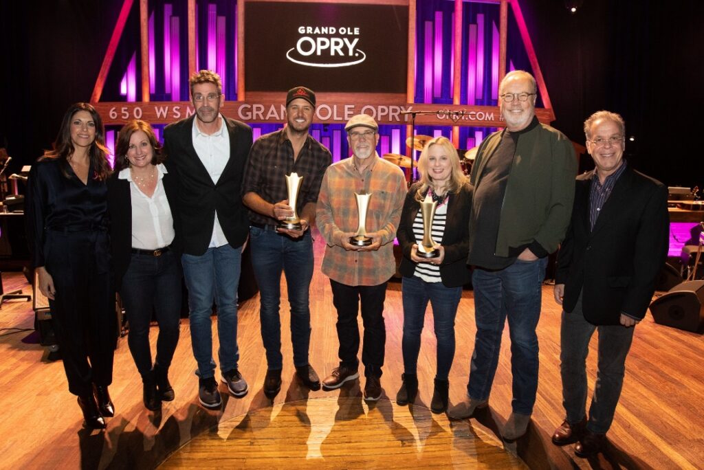 A group of people standing in front of a crowd posing for the camera



Description automatically generated