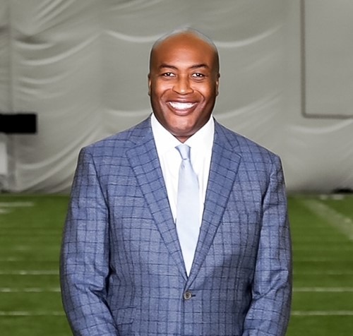 A person in a suit smiling



Description automatically generated